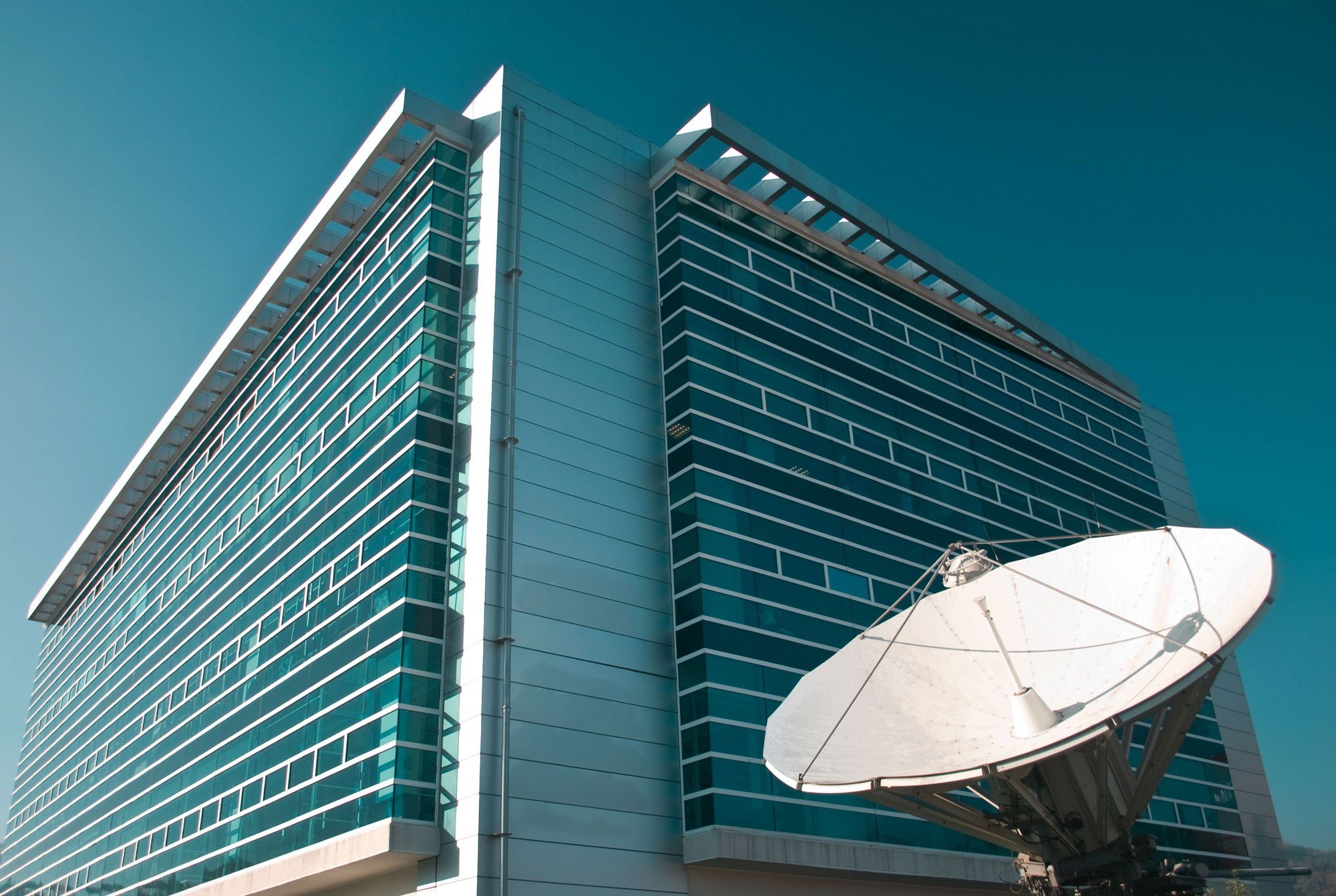 Glass office building with a satellite dish